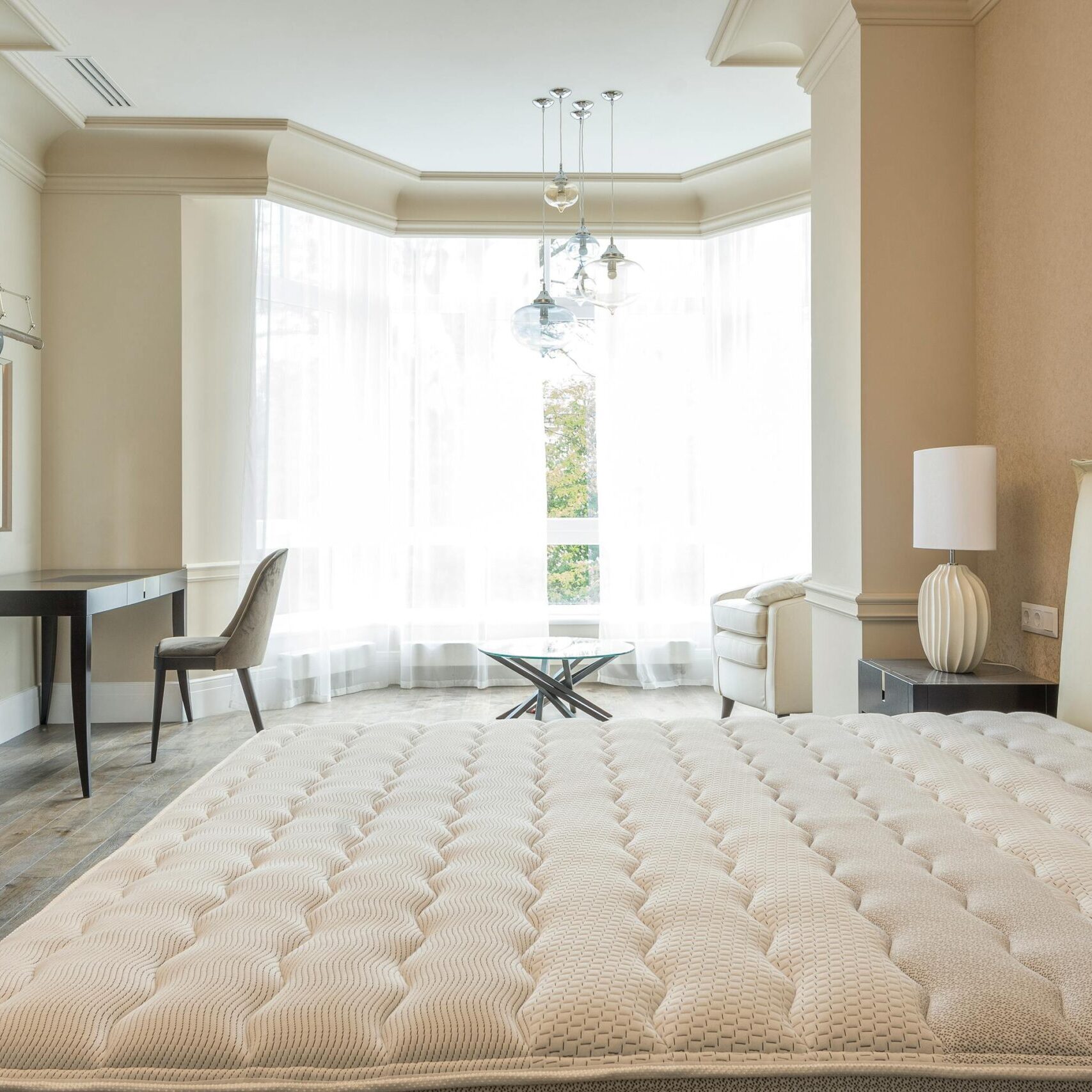 Elegant spacious bedroom with modern furniture, featuring large windows and abundant natural light.